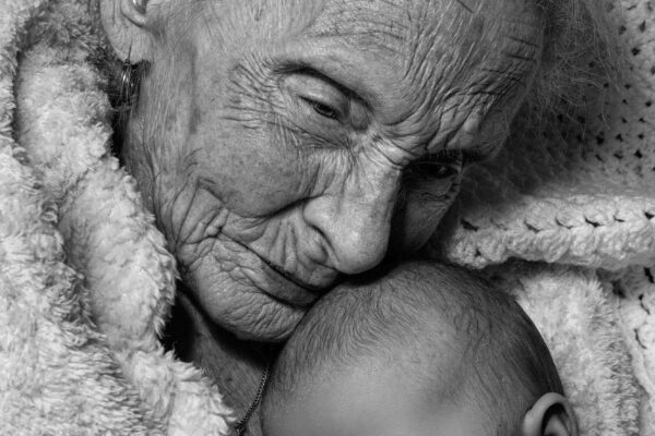 black and white close up portrait of an elderly woman and a newborn baby by Gary Lawson